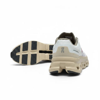 FWSports Shoes Womens On Running Cloudmonster Void in white and gold with a view of the heel and textured sole.