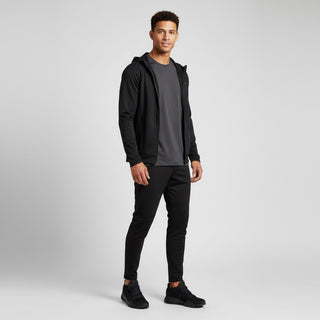 A man wearing FWSports Shoes CLOUDNOVA black running shoes with a matching black athletic outfit in a studio setting.