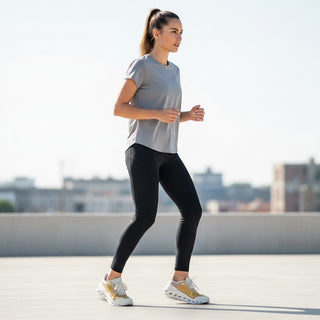 FWSports Shoes On Cloudtilt Remix sneakers in honey, gold, and white worn by a woman jogging on a rooftop.