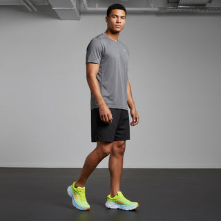 A male model wearing FWSports Shoes Hoka Bondi 8 running shoes in bright yellow with a thick cushioned white sole.