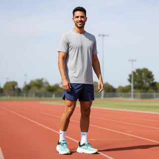 FWSports Shoes model wearing green and light blue Hoka Bondi 9 running shoes on a red outdoor track
