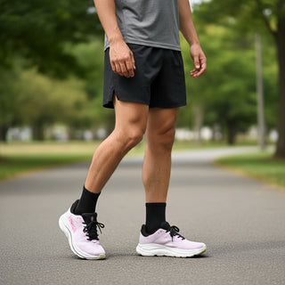 FWSports Shoes Hoka Clifton 10 running shoes in pink and black on a runner wearing black shorts on a paved path.