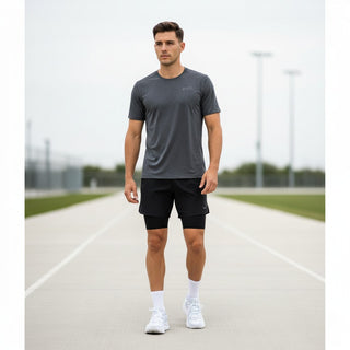 A man wearing FWSports Shoes Hoka Clifton 10 blue and white running shoes while walking on an outdoor track.