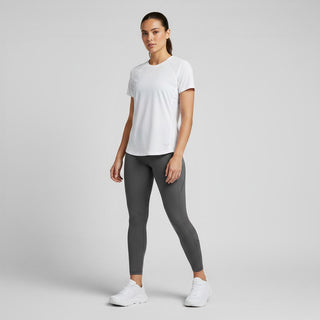 A woman wearing FWSports Shoes Hoka Clifton 10 white running shoes with a white t-shirt and grey leggings.