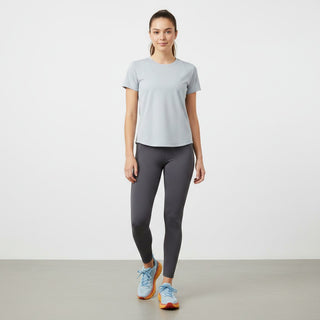 A woman wearing FWSports Shoes Hoka Clifton 8 running shoes in light blue and orange with grey leggings and a t-shirt.