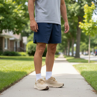 FWSports Shoes HOKA Clifton 9 running shoes in wheat shifting sand on a runner standing on a suburban sidewalk