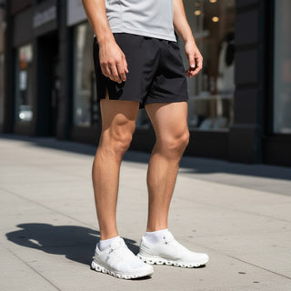 FWSports Shoes Mens On Cloud 6 Waterproof shoes in white with cushioned soles and mesh upper worn on city sidewalk