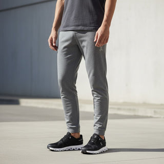 FWSports Shoes On Cloud 6 Waterproof sneakers in black and white worn by a man in grey joggers outdoors.