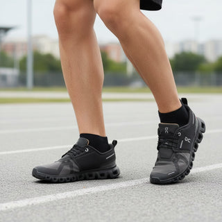 FWSports Shoes On Cloud 6 waterproof running shoes in black and gray worn by a man on a track
