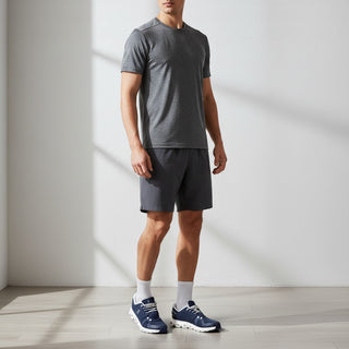 FWSports Shoes On Cloud 6 waterproof sneakers in blue and white worn by a man in athletic shorts and a grey t-shirt