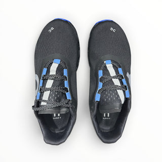 FWSports Shoes On Cloudmonster women's running shoes in black with purple and blue accents and breathable mesh upper.