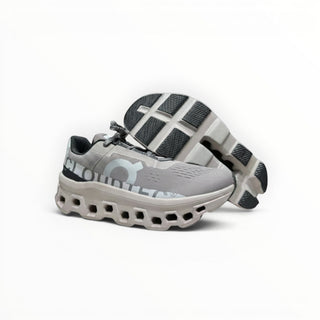 FWSports Shoes On Cloudmonster running shoes in Cinder Ash featuring breathable mesh and thick CloudTec cushioning.