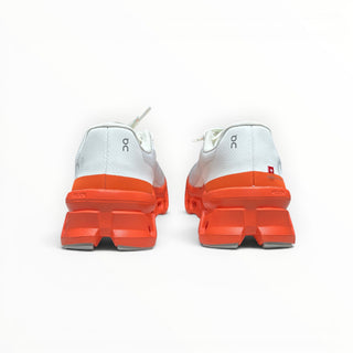 FWSports Shoes On Cloudmonster men's running shoes in white and orange red, showing the rear view of the soles.
