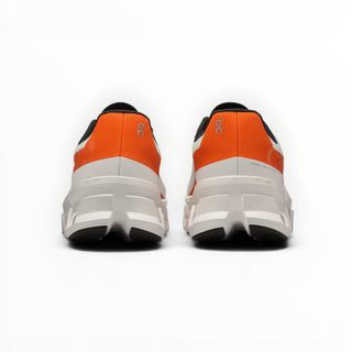 FWSports Shoes On Cloudmonster women's running shoes in white and orange, showing the rear view of the cushioned sole.