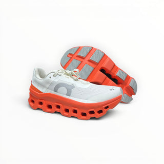 FWSports Shoes On Cloudmonster women's running shoe in white and orange red with oversized CloudTec cushioning.