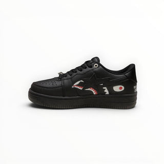 FWSports Shoes triple black low-top sneakers featuring a shark graphic side panel and lace-up closure.